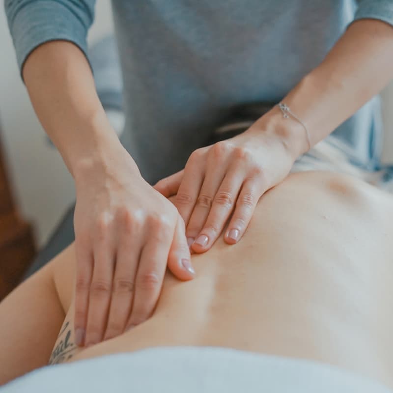 Hands working along a client's back